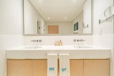 a bathroom with two sinks and a large mirror at FAM Living - Palm Tower Attached to St Regis Palm Tower 1Bed - Palm Jumeirah Views in Dubai