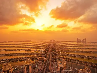 a view of a large shipyard at sunset at FAM Living - Palm Tower Attached to St Regis Palm Tower 1Bed - Palm Jumeirah Views in Dubai