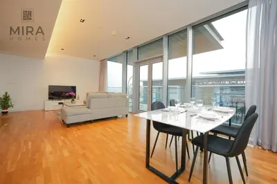 a dining room with a table and chairs and a couch at Mira Holiday Homes - Fully furnished 1 bedroom in Bluewater in Dubai