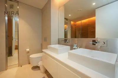 a white bathroom with a sink and a toilet at Mira Holiday Homes - Fully furnished 1 bedroom in Bluewater in Dubai