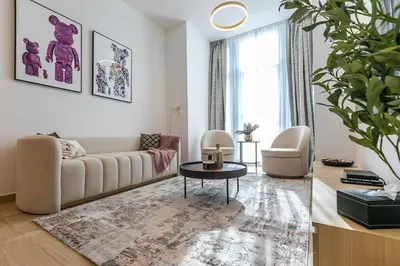 a living room with a couch and a table at Stunning 1 Bedroom Apartment - Regina Tower - JVC in Dubai