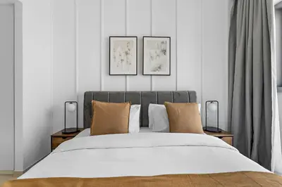 a bedroom with a bed with three pictures on the wall at Silkhaus lavish 1BDR in new tower with pool & gym access in Dubai