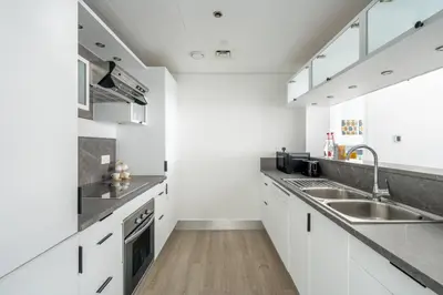 a kitchen with white cabinets and a sink at GuestReady - Moment in time at Al Majara in Dubai