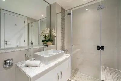 a white bathroom with a sink and a shower at GuestReady - Moment in time at Al Majara in Dubai