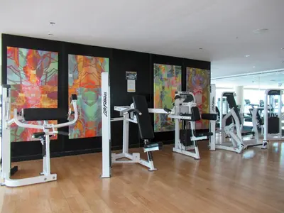 a gym with several tread machines in a room at GuestReady - Moment in time at Al Majara in Dubai