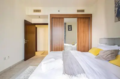 a bedroom with a large white bed with yellow pillows at Most enjoyable 2BR apartment in Dubai marina in Dubai