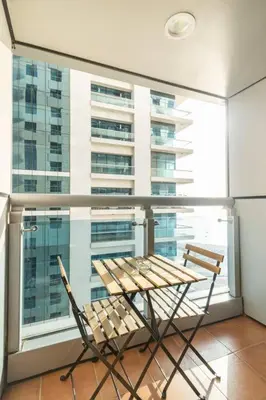 a chair sitting in front of a large window at Most enjoyable 2BR apartment in Dubai marina in Dubai