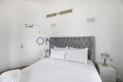 a bedroom with a large white bed with white pillows at Stunning Lake View - Height Floor - Furnished 1BR in Dubai