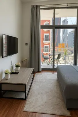 a living room with a bed and a large window at Cozy Apartment in Jumeirah Village Circle, Dubai. in Dubai