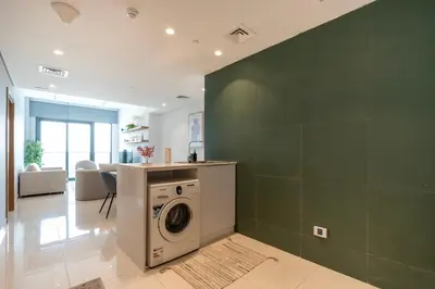 a laundry room with a washer and a green wall at Appartement Dubai in Dubai