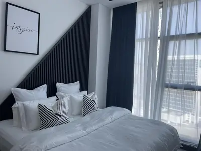 a bedroom with a bed with white pillows and a window at Iconic !Luxurious 1 Bed Apartment! in Dubai