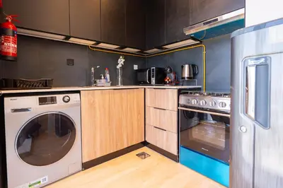 a kitchen with a stove and a washer and dryer at Le Villa-Joie !Bright Studio Apartment! in Dubai