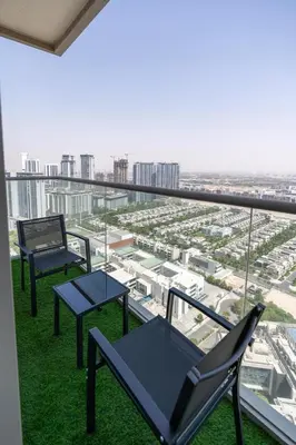 two chairs and tables on a balcony with a view at STAY BY LATINEM Luxury 1BR Holiday Home CVR A2910 Near Burj Khalifa in Dubai