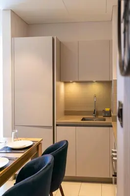 a kitchen with a table and chairs and a sink at STAY BY LATINEM Luxury 1BR Holiday Home CVR A2910 Near Burj Khalifa in Dubai