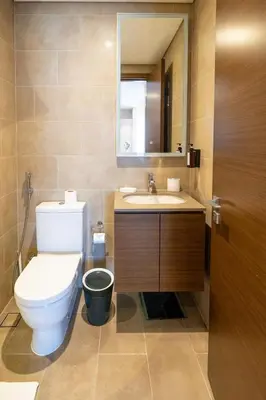 a bathroom with a toilet and a sink and a mirror at STAY BY LATINEM Luxury 1BR Holiday Home CVR A2910 Near Burj Khalifa in Dubai