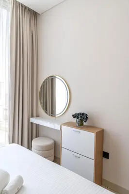 a white bedroom with a mirror and a dresser at STAY BY LATINEM Luxury 1BR Holiday Home CVR A2910 Near Burj Khalifa in Dubai