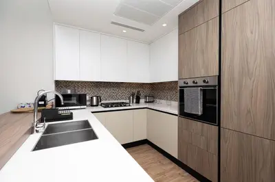 a kitchen with white cabinets and a sink at LUXURY 1 BR Apartment at Marina Gate Jumeirah Living in Dubai