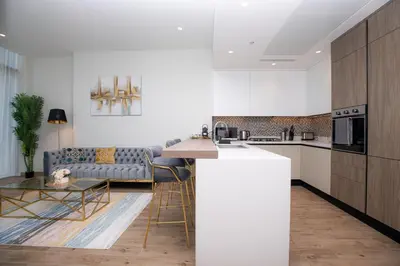 a kitchen and living room with a couch and a table at LUXURY 1 BR Apartment at Marina Gate Jumeirah Living in Dubai