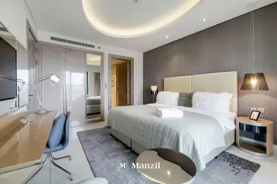 a bedroom with a large bed and a tv at Manzil - Ultra Luxury 1BR apartment Paramount Tower with Burj Khalifa and Downtown Views in Dubai