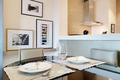 a dining table with two plates and glasses on it at Manzil - Ultra Luxury 1BR apartment Paramount Tower with Burj Khalifa and Downtown Views in Dubai
