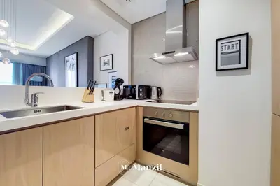 a kitchen with a sink and a stove at Manzil - Ultra Luxury 1BR apartment Paramount Tower with Burj Khalifa and Downtown Views in Dubai