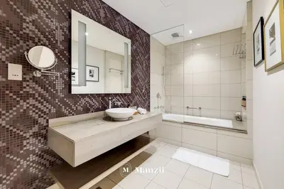 a bathroom with a sink and a mirror and a tub at Manzil - Ultra Luxury 1BR apartment Paramount Tower with Burj Khalifa and Downtown Views in Dubai