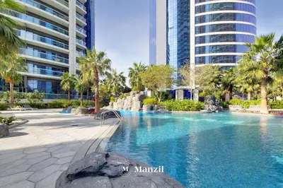 a swimming pool in a resort with palm trees and buildings at Manzil - Ultra Luxury 1BR apartment Paramount Tower with Burj Khalifa and Downtown Views in Dubai