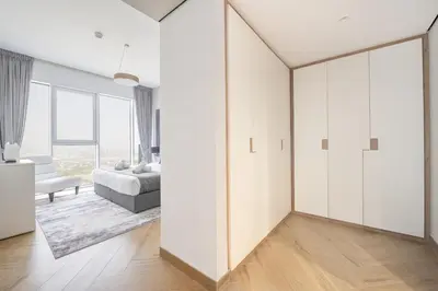 a bedroom with white walls and a large mirror at Ultra Luxury Wasl 1 Residences Zabeel Park in Dubai