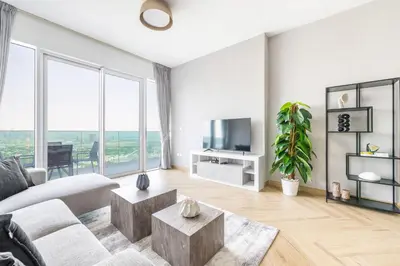 a living room with a couch and a tv at Ultra Luxury Wasl 1 Residences Zabeel Park in Dubai