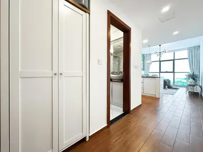 a living room with white cabinets and a large mirror at Trophy - Urban Oasis Suite in Dubai