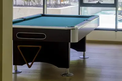 a pool table sitting on top of a wooden floor at Elegant Apartment Amidst Vibrant Area With Balcony in Dubai