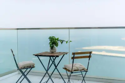 two chairs and a table with a plant on a balcony at GuestReady - Beachfront heaven with stunning views in Dubai