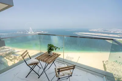 a balcony with a table and two chairs and the beach at GuestReady - Beachfront heaven with stunning views in Dubai
