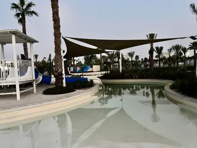 a pool at a resort with palm trees and a tent at Dubai Private Pool villa Damac Hills 2 deleguest in Dubai