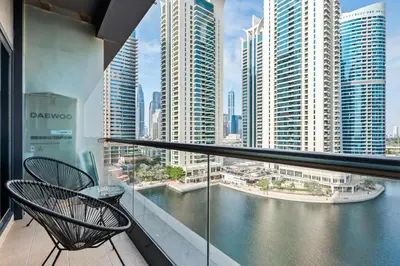 a balcony with two chairs and a view of a city at Luxury JLT Studio Lakeview Pool & Marina Walk in Dubai