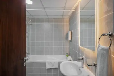 a bathroom with a bath tub and a sink at Furnished studio in Arch Tower, JLT near metro in Dubai