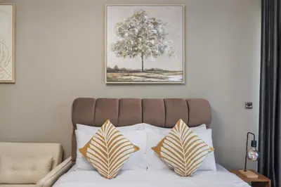 a bed with two pillows on it with a picture above it at Furnished studio in Arch Tower, JLT near metro in Dubai