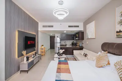 a living room with a couch and a tv in a room at Furnished studio in Arch Tower, JLT near metro in Dubai