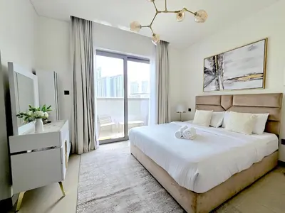 a bedroom with a large bed and a large window at Sleek and Stylish 2-Bedroom Apartment in Dubai