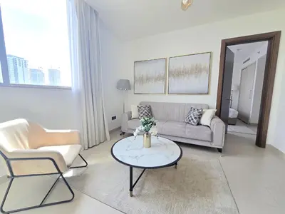 a living room with a couch and a table at Sleek and Stylish 2-Bedroom Apartment in Dubai