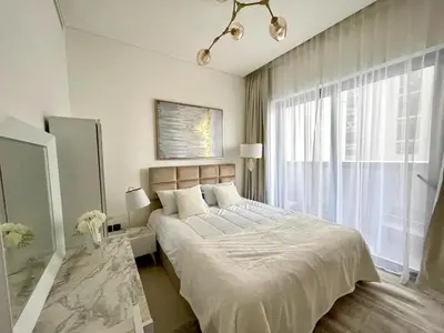 a bedroom with a large bed and a large window at New 1 bedroom in Sobha Hartland in Dubai