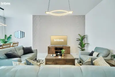 a living room with a couch and a table at bnbme - Luxury 2BR Business Bay Apt w Canal Views Pool Gym Free Parking Downtown in Dubai