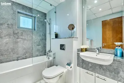 a bathroom with a toilet and a sink at bnbme - Luxury 2BR Business Bay Apt w Canal Views Pool Gym Free Parking Downtown in Dubai