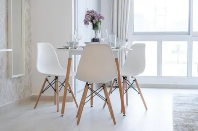 a dining room with white chairs and a table at Spacious Serene Studio Retreat in JVC by Suiteable in Dubai