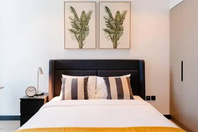 a bedroom with a bed and two paintings on the wall at Stylish studio next to canal in Dubai