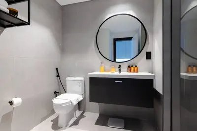 a bathroom with a white toilet and a mirror at Stylish studio next to canal in Dubai