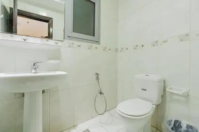 a white bathroom with a toilet and a sink at RH- Spacious, Stylish, 01BR near Mall of Emirates in Dubai