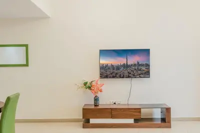 a living room with a table and a picture on the wall at RH- Spacious, Stylish, 01BR near Mall of Emirates in Dubai