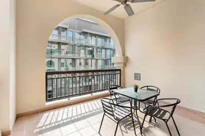a balcony with a table and chairs and a window at StoneTree - Fairmont South 2 BR - Near Beach in Dubai