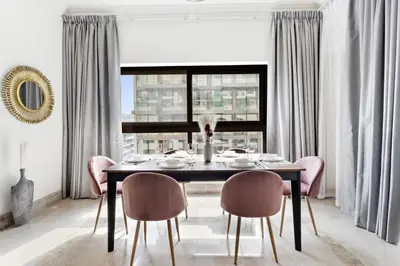 a dining room with a table and chairs and a window at StoneTree - Fairmont South 2 BR - Near Beach in Dubai
